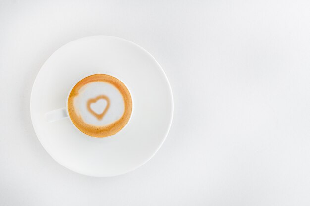 Una taza de café aromático con un corazón de arte latte dentro