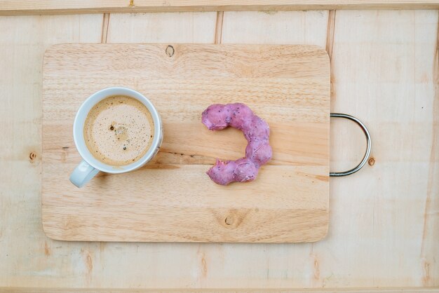 taza de café aromático con donut en el fondo de madera