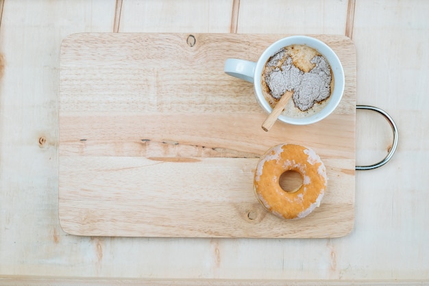 taza de café aromático con donut en el fondo de madera