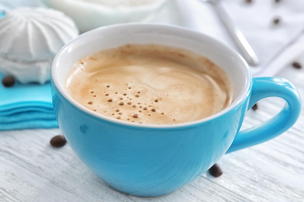 Taza de café aromático por la mañana en la mesa de madera