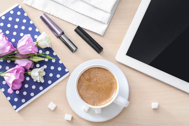 Taza de café aromático matutino y tableta en la mesa