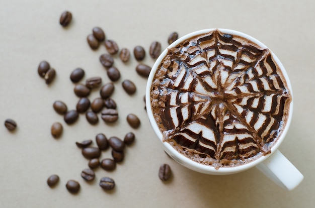 Una taza de café con arte del latte en el fondo de papel marrón