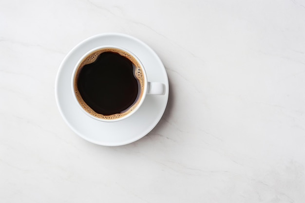 Una taza de café con asa en un plato blanco.