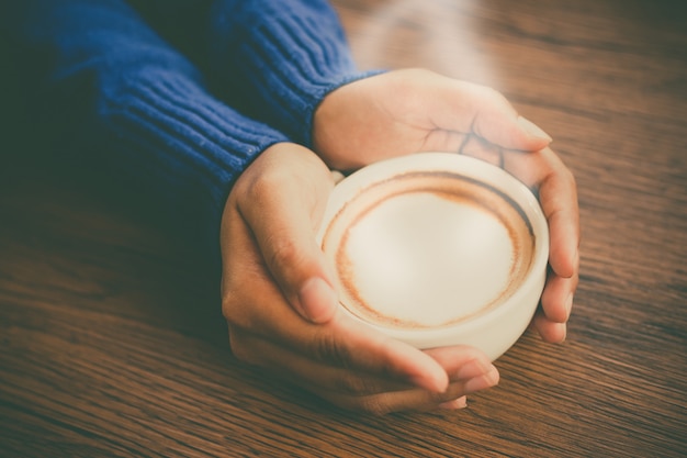 Taza de café asimiento de la mano