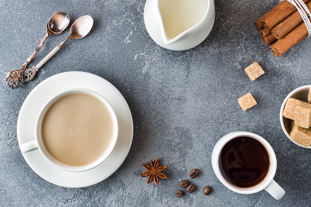 Taza de café, azúcar moreno y canela con anís sobre concreto. Copia espacio