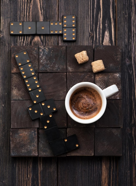 Taza de café con azúcar sobre un fondo de madera oscura.