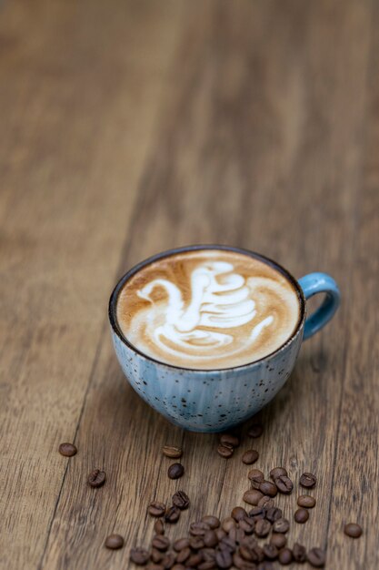 Taza de café azul y granos de café.