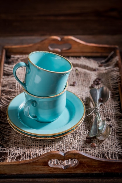 Taza de café azul rústico en bandeja de madera vieja