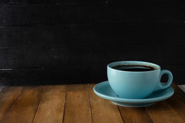 Taza de café azul sobre fondo negro