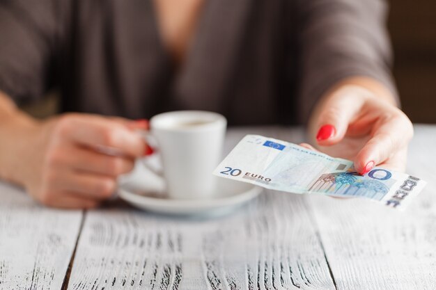 Taza de café y billete de 20 euros