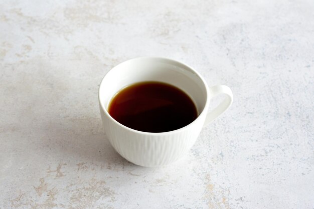 taza de café blanca aislada sobre fondo de mármol, primer plano