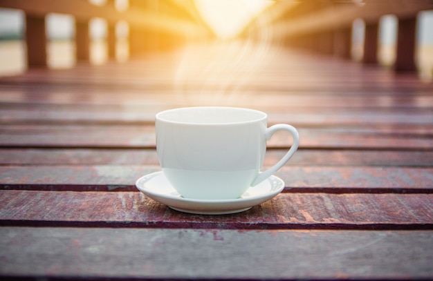 Taza de café blanca en el fondo de madera para el concepto de la bebida del café