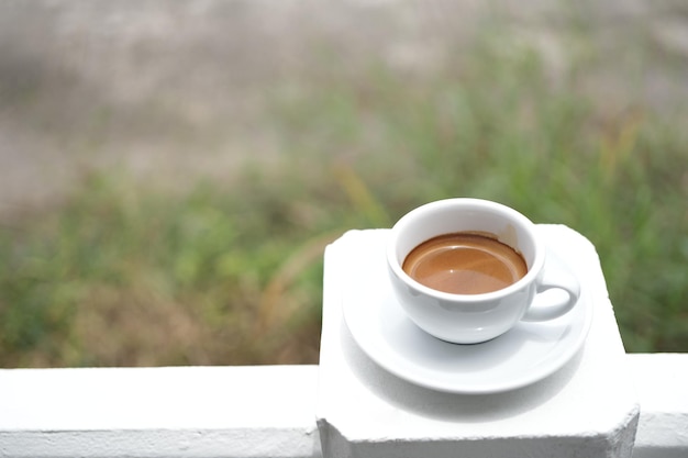 Taza de café blanca en una mesa de madera blanca