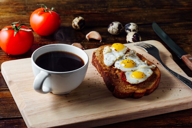 Taza de café y bruschetta con huevos fritos