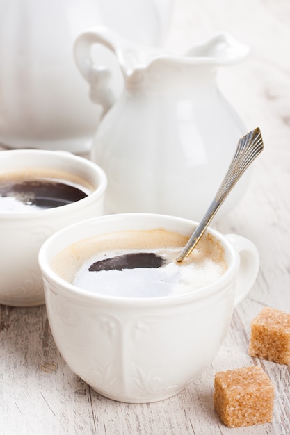 Taza de café con cachorros de azúcar y jarra de leche