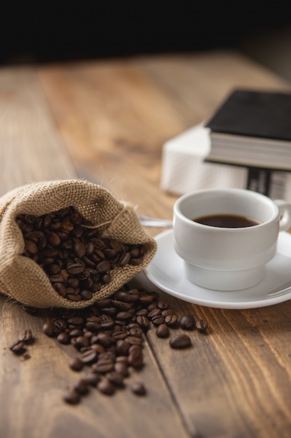 Taza con café caliente y algunos libros para leer.