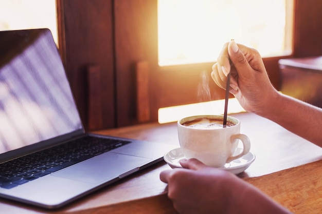 La taza de café caliente en el escritorio está un poco humeante.