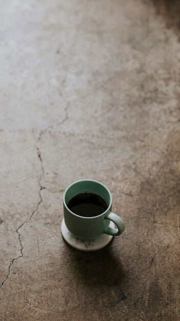 Taza de café caliente en el fondo de pantalla del teléfono móvil piso de concreto