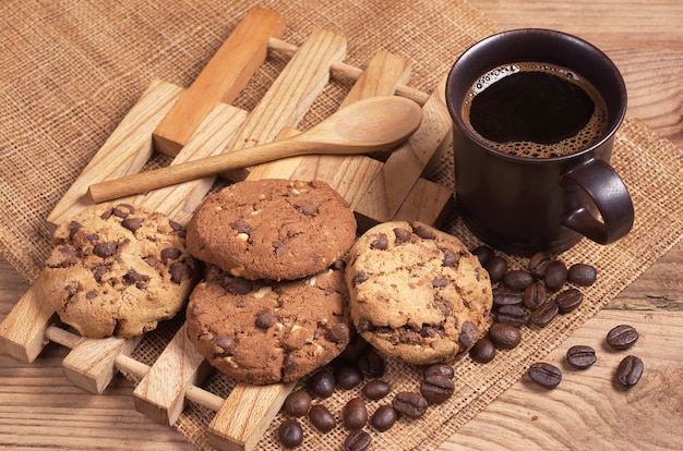 Foto taza de café caliente y galletas con chocolate para el desayuno en la mesa de madera rústica