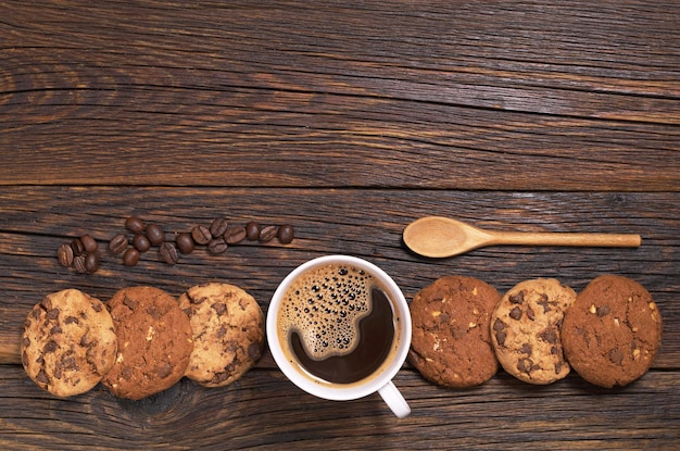 Foto taza de café caliente y galletas de chocolate en la vista superior de la mesa de madera oscura espacio para texto