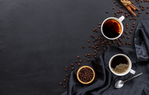 Taza de café caliente y grano de café con varios utensilios.