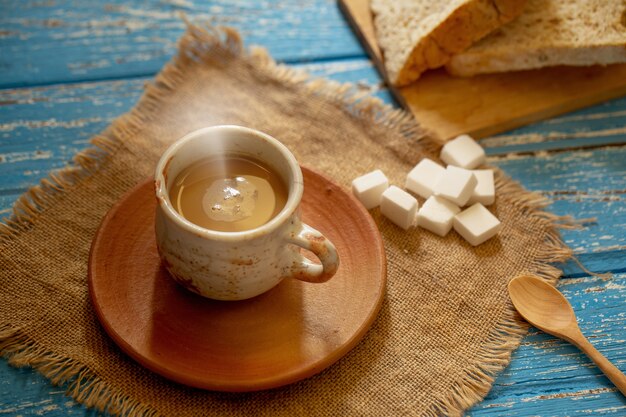 Taza de café caliente por la mañana en una mesa de madera rural azul