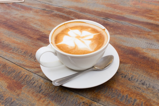 Taza de café caliente en la mesa de madera