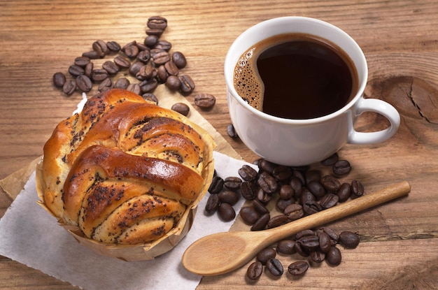 Taza de café caliente y pasteles caseros con semillas de amapola en una mesa de madera antigua