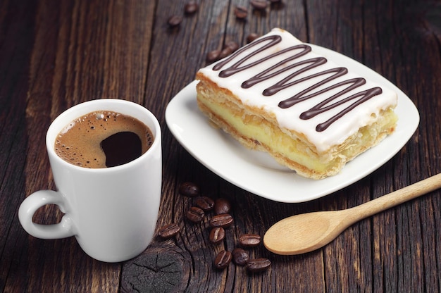 Taza de café caliente y tarta con chocolate en la mesa de madera antigua