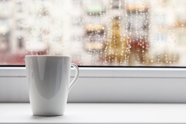 Taza de café caliente en la ventana