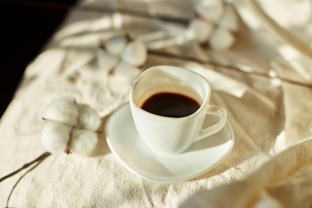 Taza de café en la cama con flores de algodón estado de ánimo matutino Ropa de cama textil de algodón orgánico y natural espacio de copia