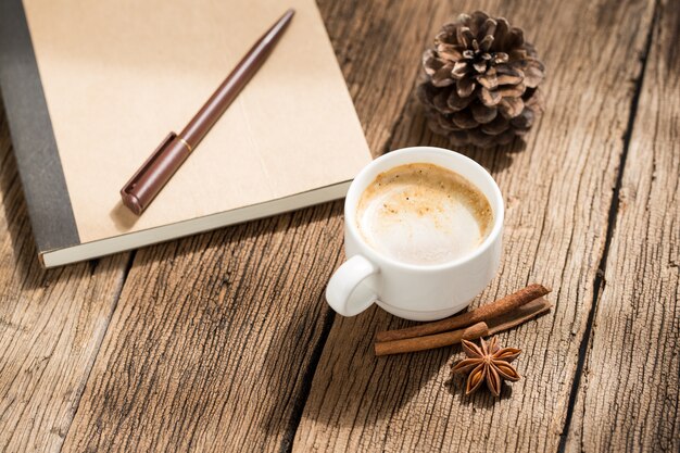 taza de café y canela en la mesa de madera vieja