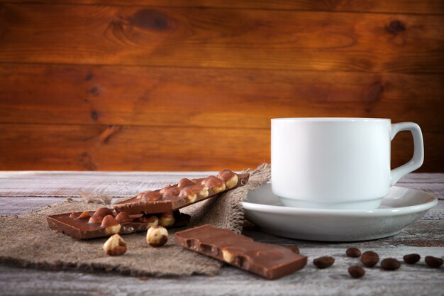 Taza de café con un capitán delgado sobre una mesa de madera