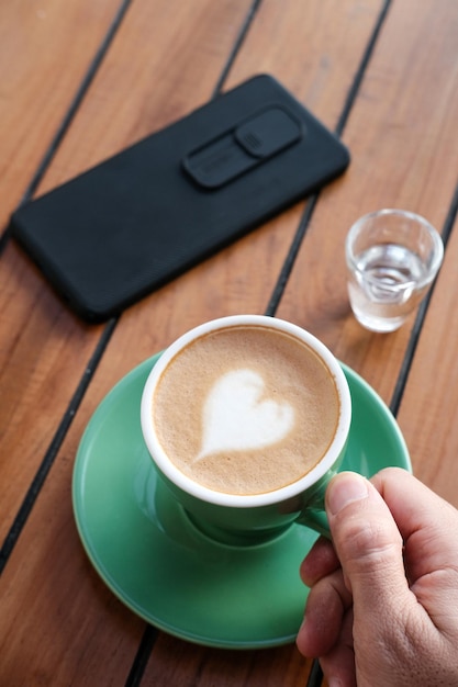 Una taza de café capuchino con leche caliente en la mesa para el desayuno