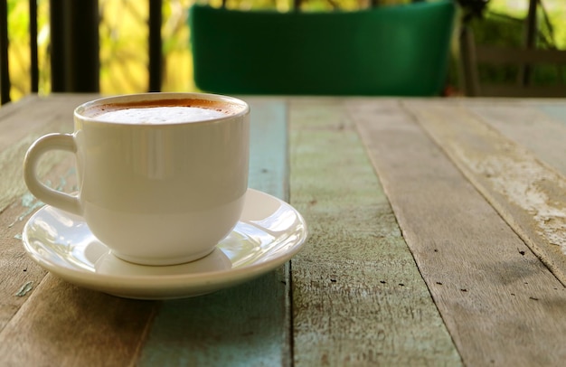 Taza de café capuchino en mesa de madera de estilo rústico