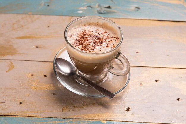 Taza de café capuchino en mesa de madera