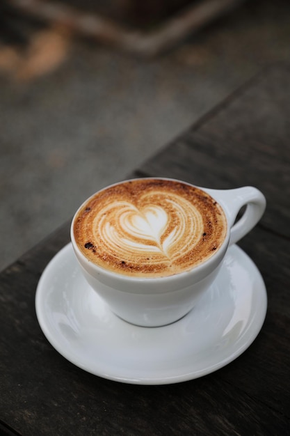 Taza de café capuchino sobre fondo de madera