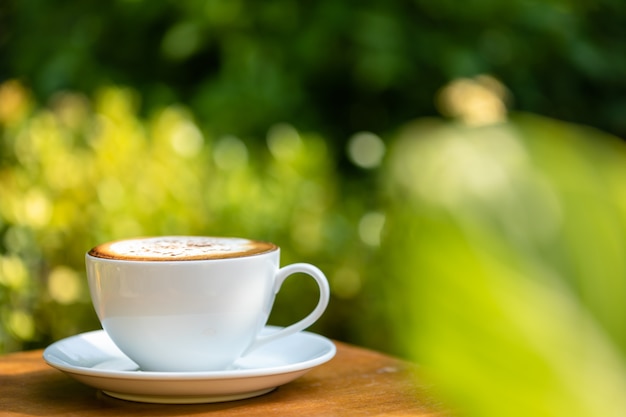 Taza de café de cerámica blanca en mesa de madera