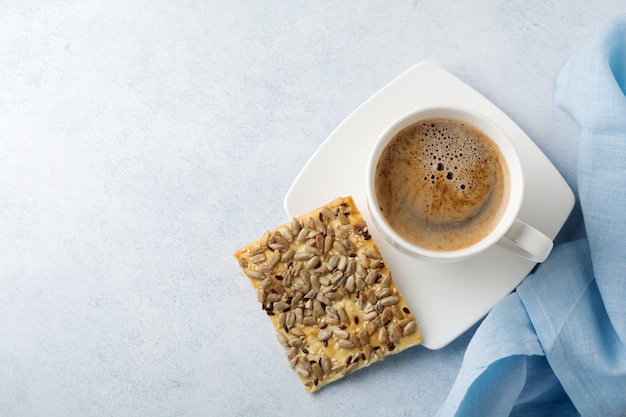 Taza de café de cerámica con galletas saludables.