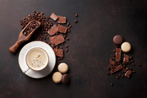 Taza de café con chocolate y macarrones en la mesa de la cocina antigua