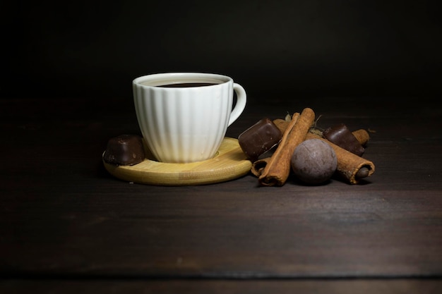 taza de café y chocolate sobre el fondo de madera