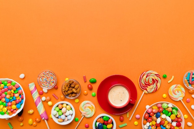 Taza de café con chocolates y dulces de colores Vista superior en el fondo de la mesa con espacio de copia