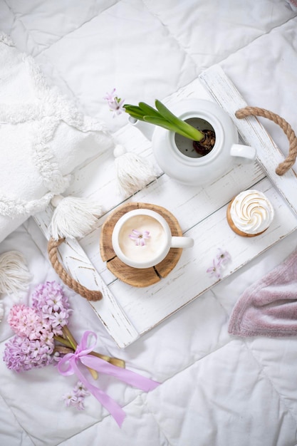 Una taza de café con una cinta morada sobre una mesa de madera