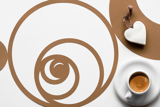 Taza de café, círculo de secuencia de Fibonacci con granos de café. Espresso, sabrosa perfección. Forma de corazón. Concepto de proporción áurea, arte en papel. Vista superior, plano en dos tonos de color marrón blanco sobre blanco.