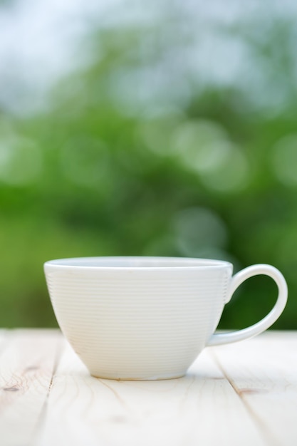 Taza de café colocada sobre un fondo de mesa de madera bokeh.