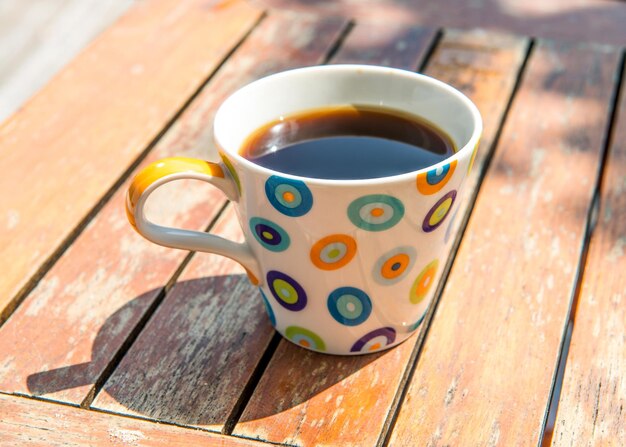 Taza de café colorida en la mesa de madera