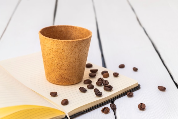 Taza de café comestible con granos tostados sobre fondo blanco imagen de estilo de vida concepto de desperdicio cero