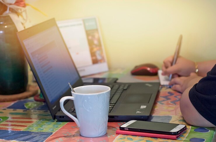 Foto taza de café y computadora portátil en la mesa