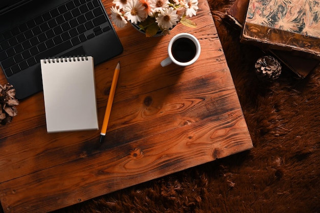 Foto taza de café de la computadora portátil vacía y libro vintage en la mesa de madera