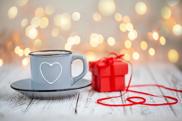 Taza de café con corazón y caja roja presente, concepto de San Valentín,